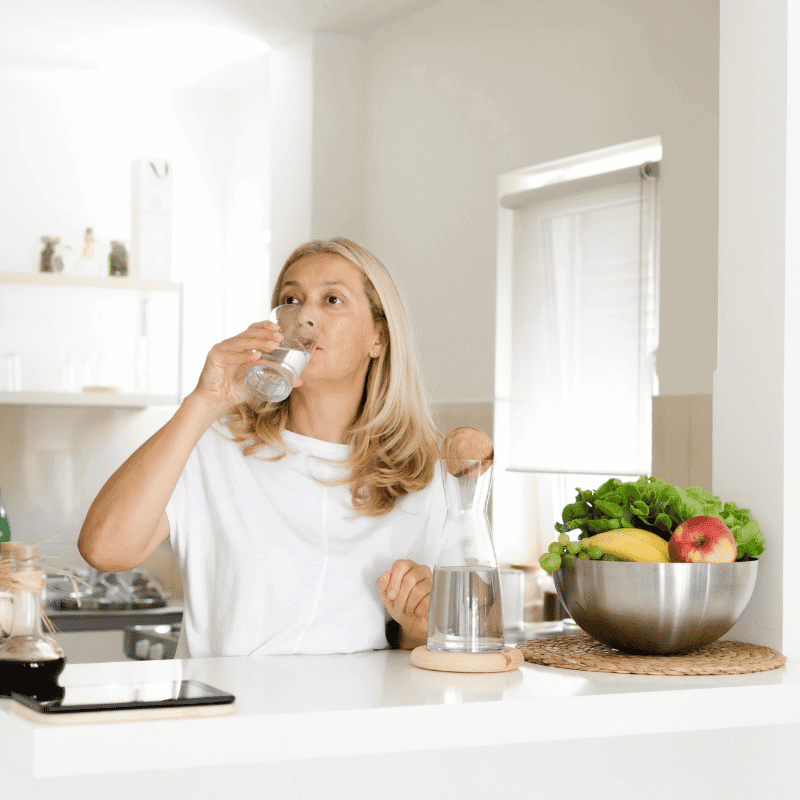 a women is drinking water from a glass